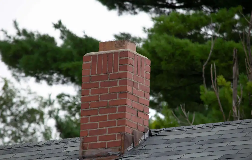 Brick chimney on a sloped roof before removal
