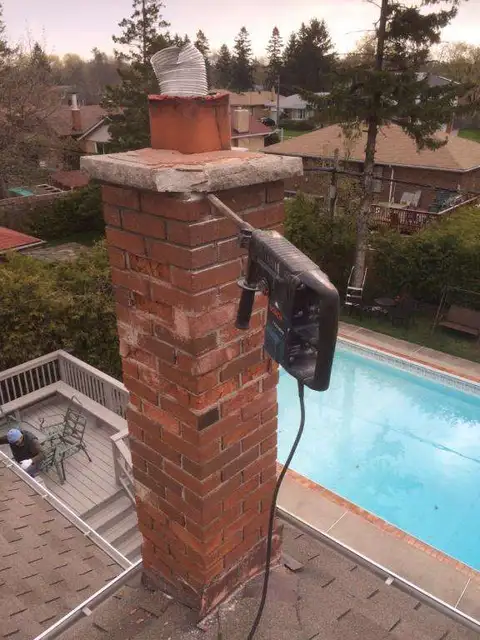 Chimney being removed near a backyard pool